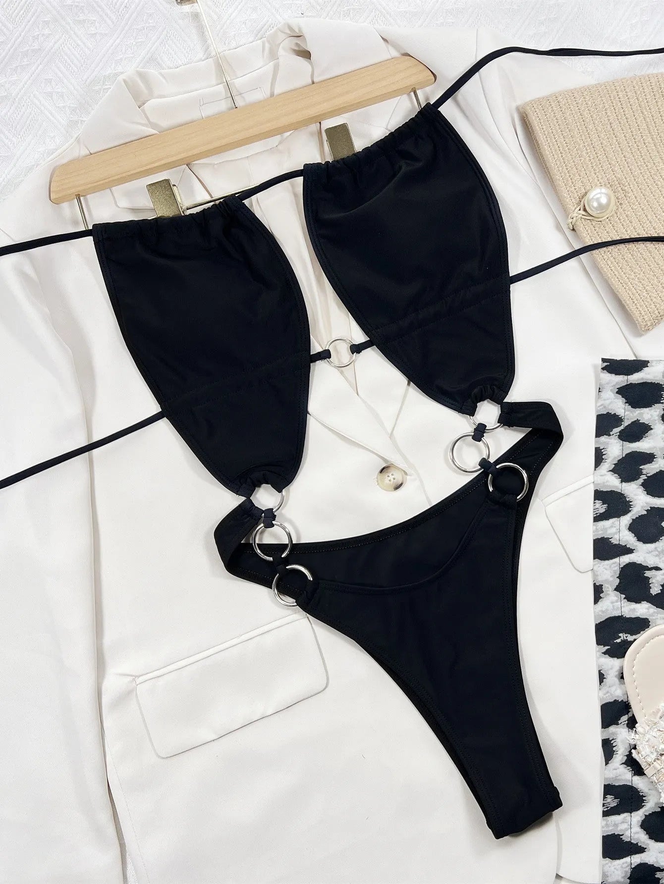 Black sleeveless one-piece swimsuit for women on a hanger