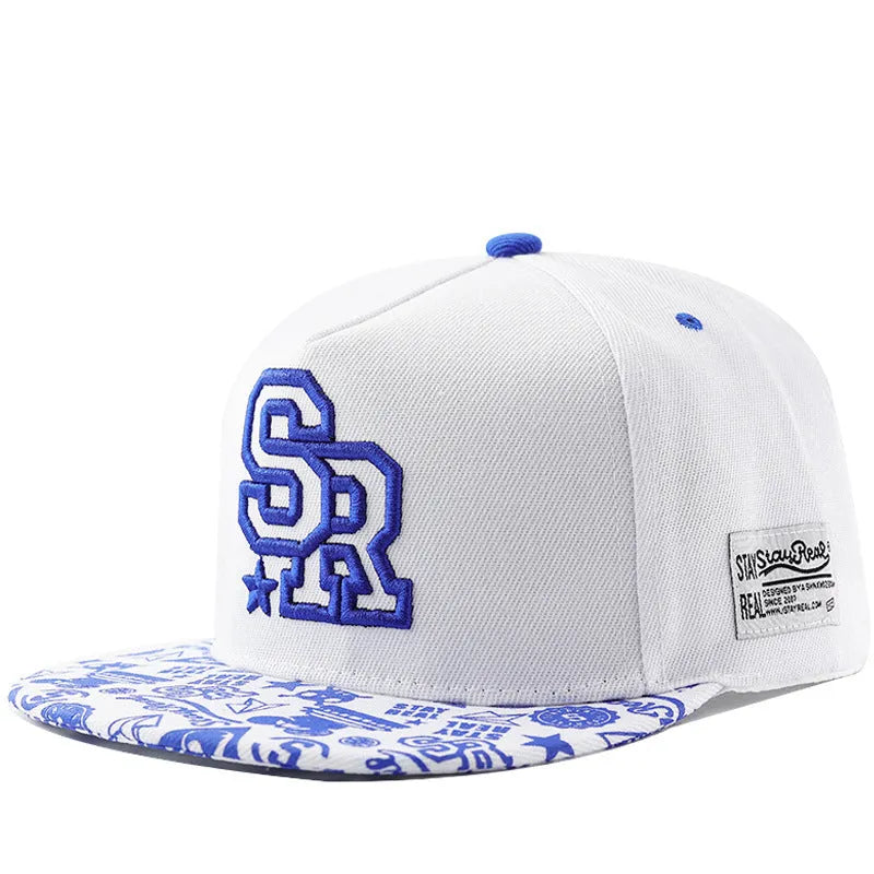 Cotton baseball cap with embroidered letters in black or white, showing adjustable strap and dome crown.