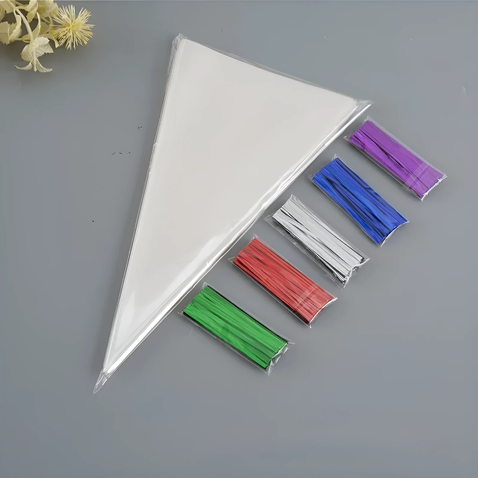 Clear triangle-shaped plastic packaging bag with a twisted top secured by a white tie wire.