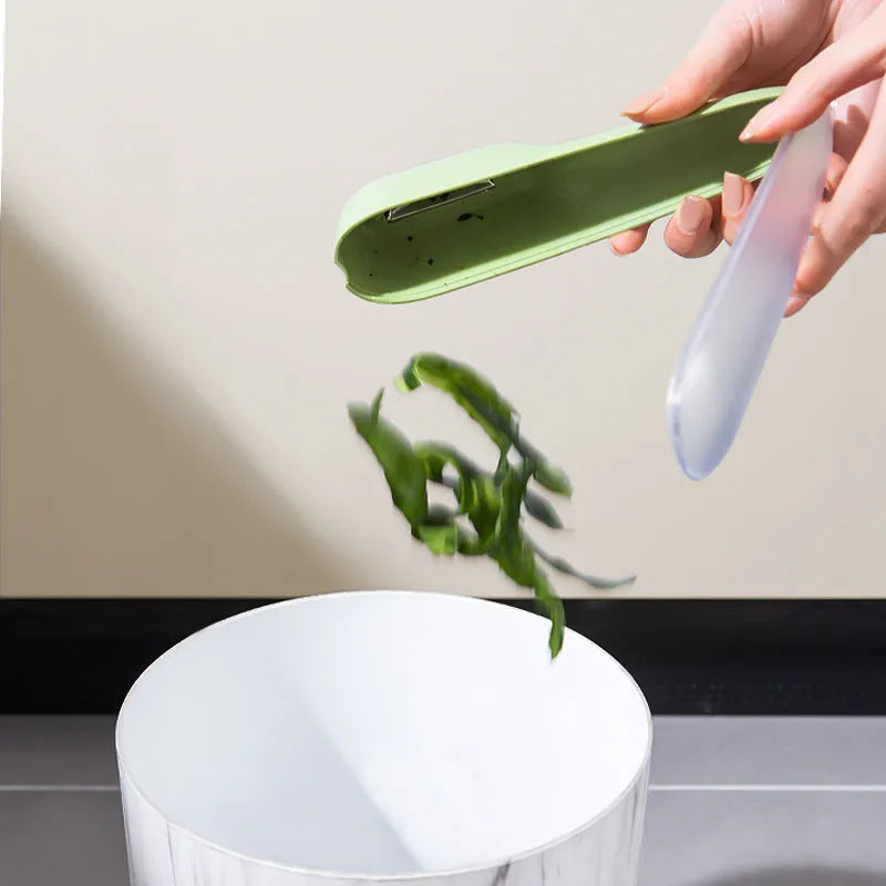 Dark green peeling knife with a storage tube and stainless steel blade on a kitchen worktop.