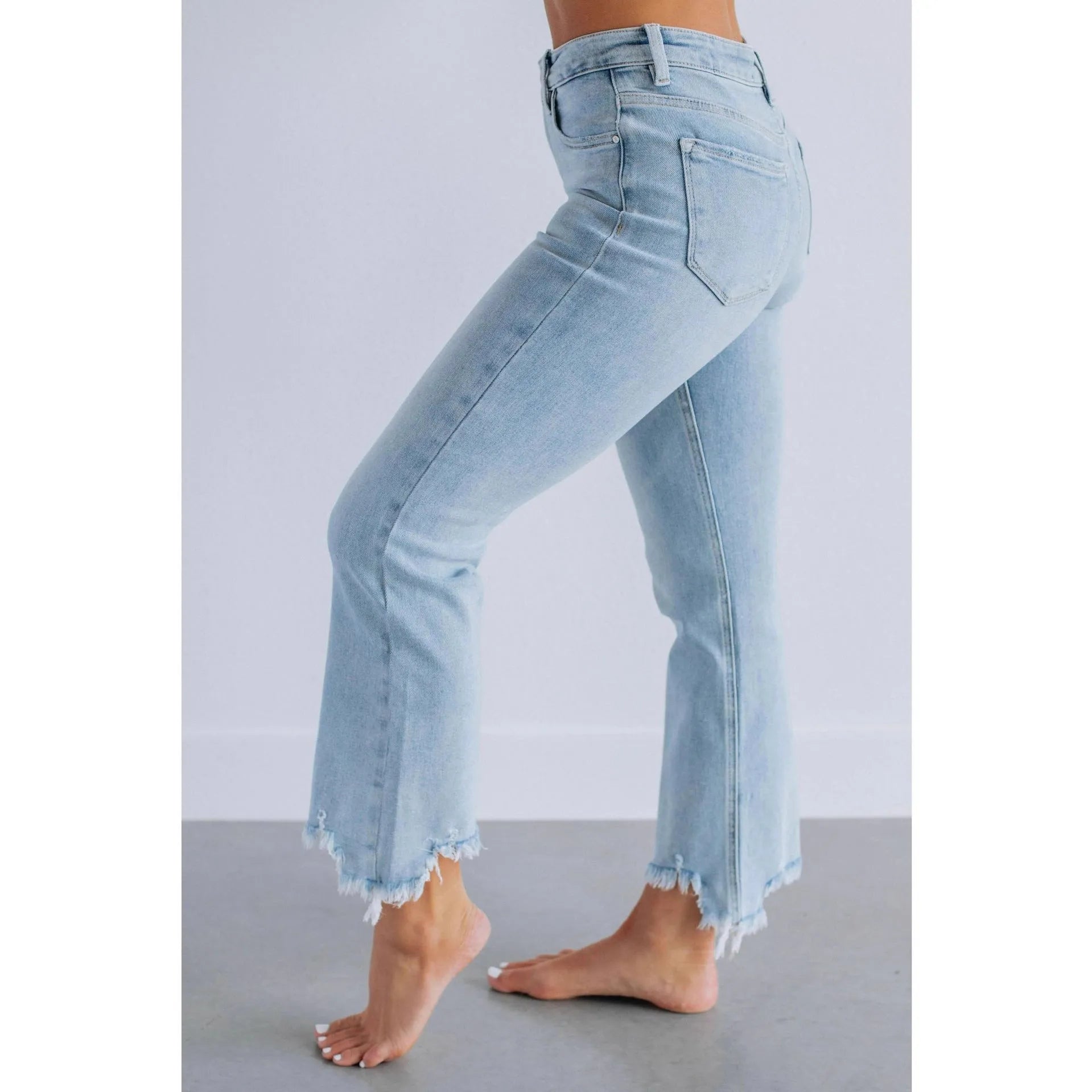 Women's dark blue denim casual trousers with a hand-distressed finish on a hanger.