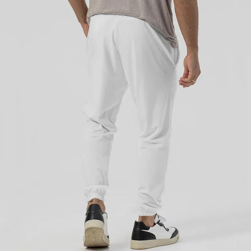 Men's grey loose tapered casual track sweatpants with a straight leg and elastic waistband.