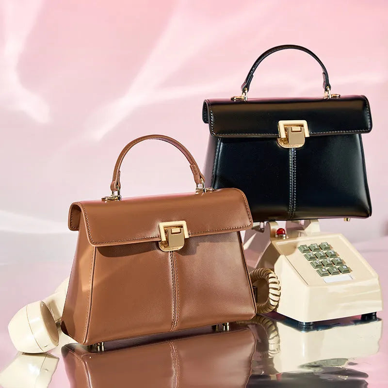 Black genuine leather women's shoulder bag with a vachette clasp, shown open to reveal a zippered hidden pocket.