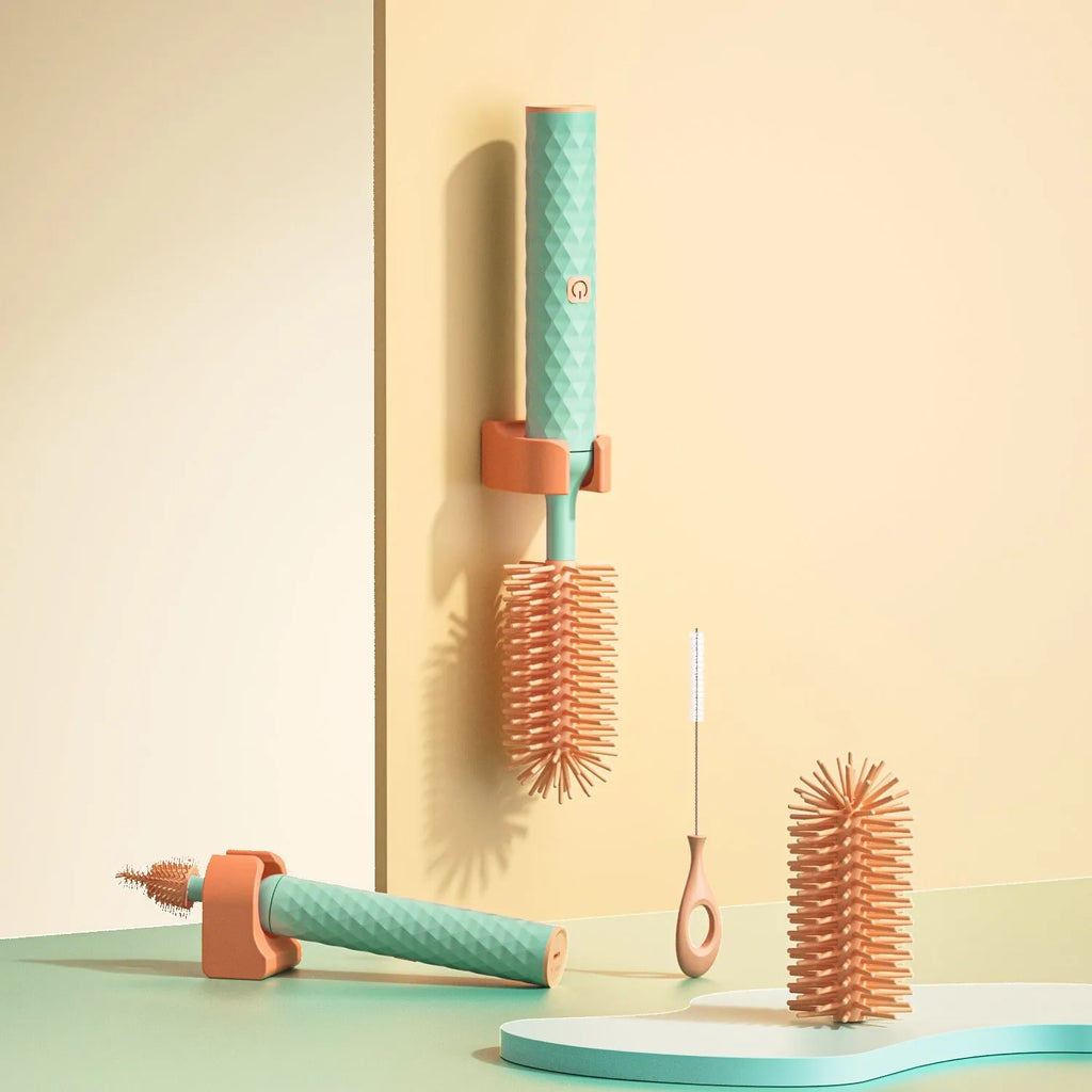 Pink and green electric baby bottle brush with rotating silicone head and USB charging cable