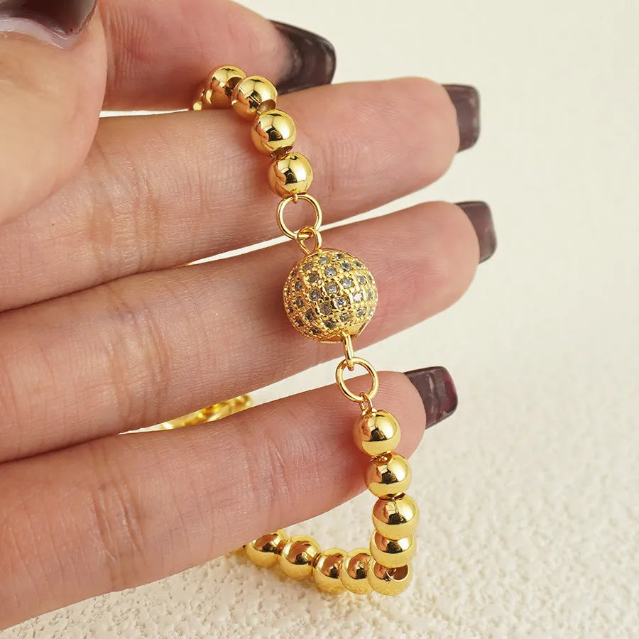 Close-up of a women's copper bracelet with a heart shape and a single round zircon stone in an Arabic-style design.