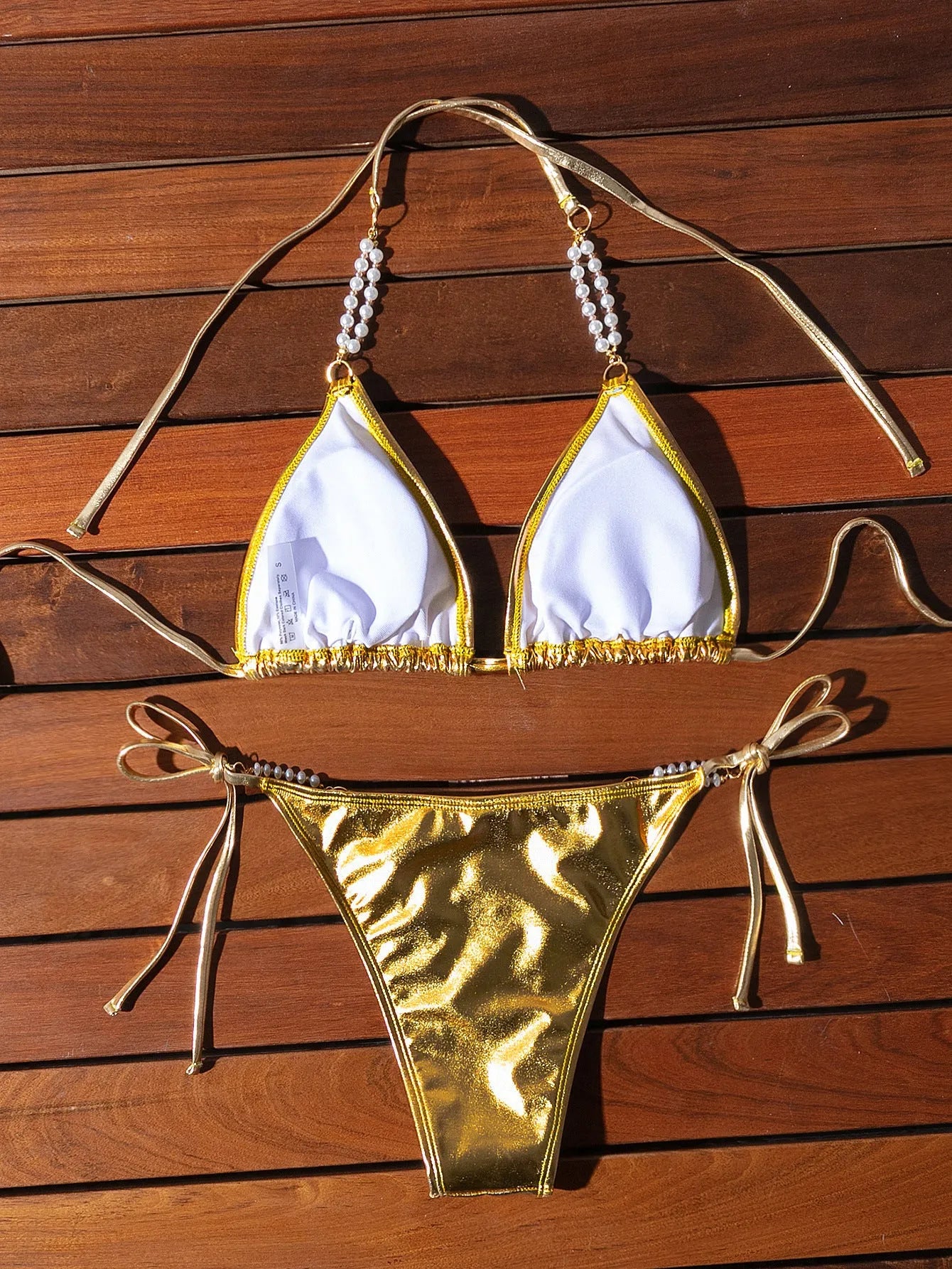Gold halter lace-up bikini swimsuit with pearl chain detail, shown in Asian sizes