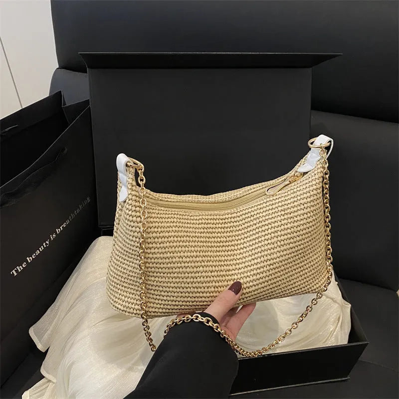 Khaki straw woven horizontal square tote bag with shoulder straps and outer sandwich pocket.