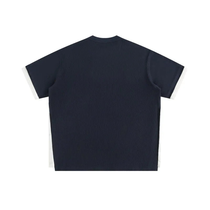 Retro alphabet embroidered loose waffle knit t-shirt in navy blue, shown on a hanger.