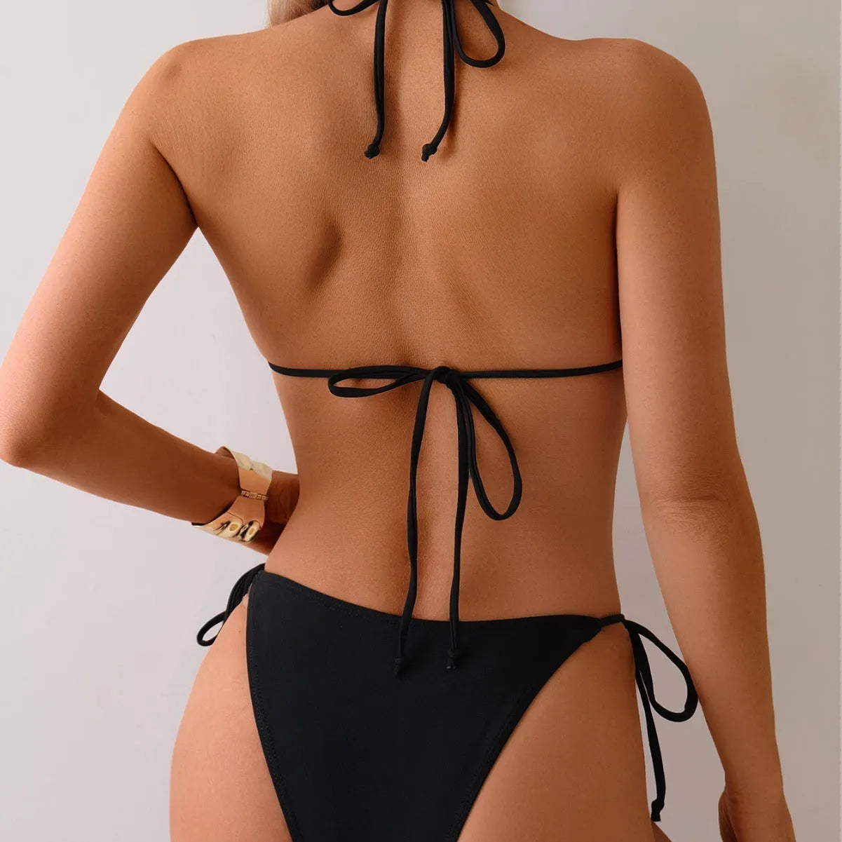 Black women's bikini swimsuit with metal bead detail and split-front design