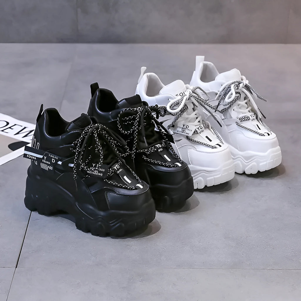 Women's white and black platform tennis shoes with mesh upper and cross-strap.