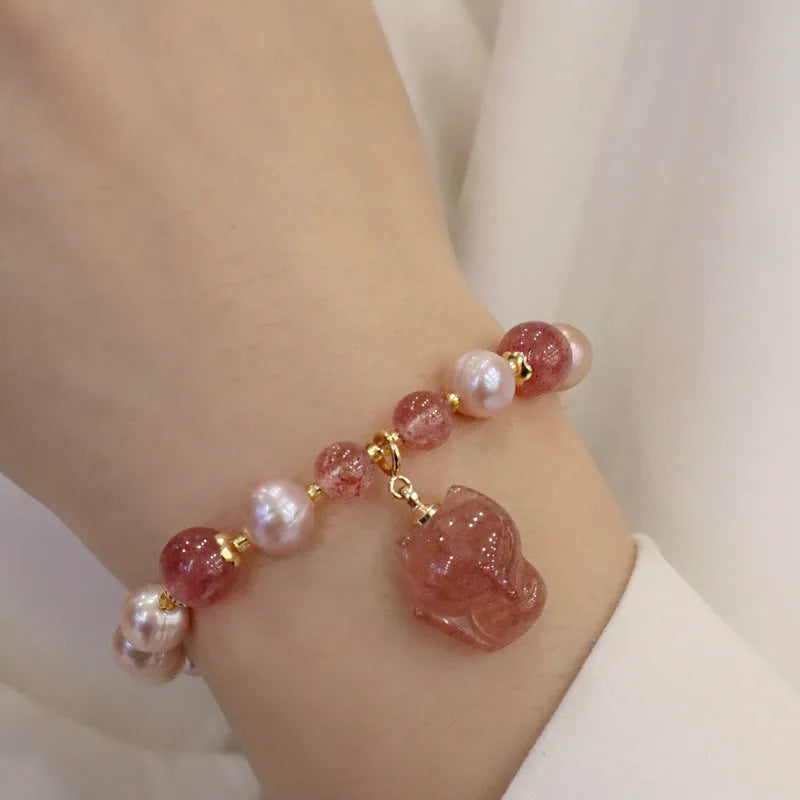 Women's light pink freshwater pearl bracelet with a small fox charm on a natural background.