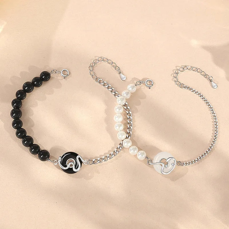 Close-up of a 925 sterling silver bracelet with a snake design, obsidian pearl, and a safe buckle clasp.