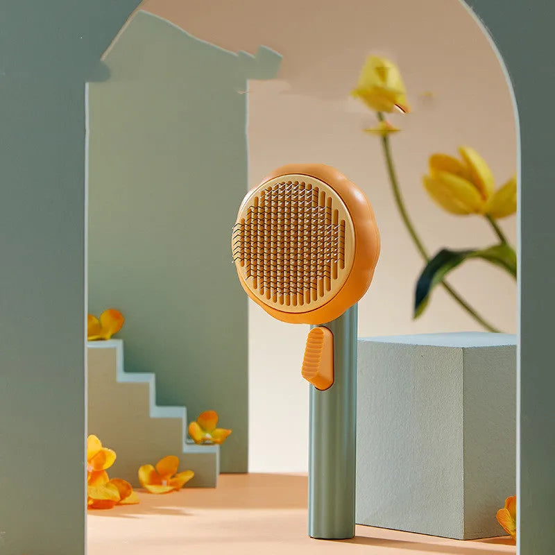 Hand-held pet grooming brush with curved stainless steel teeth in pumpkin colour option