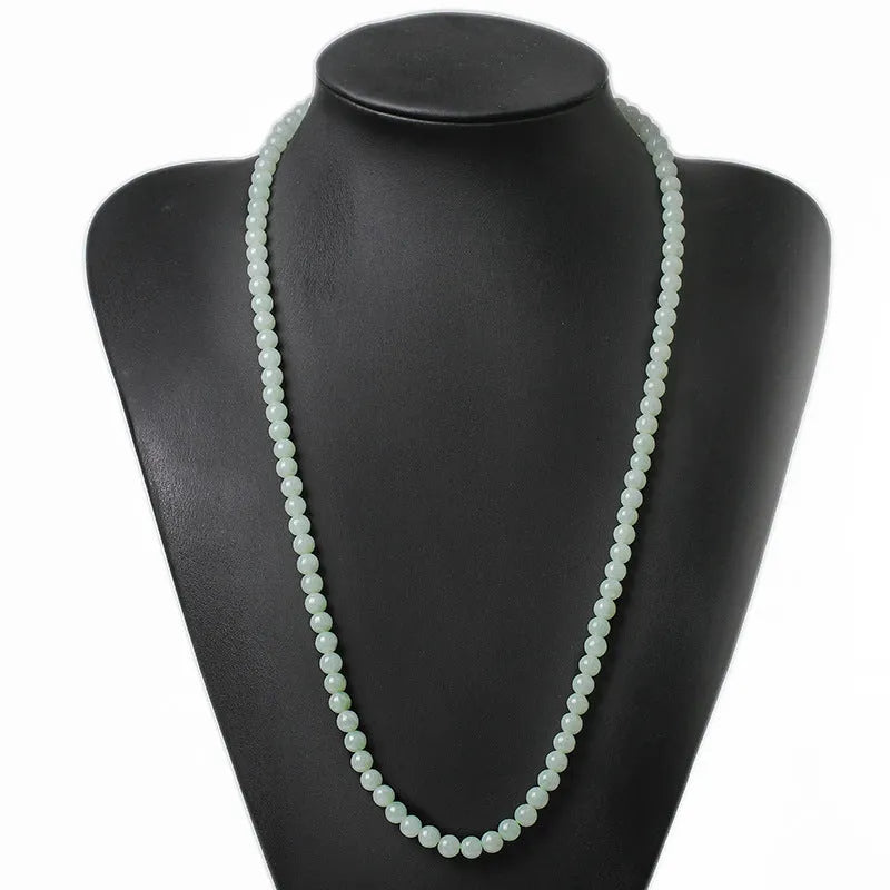 Adjustable necklace with a round white and green jade bead on a silver chain.