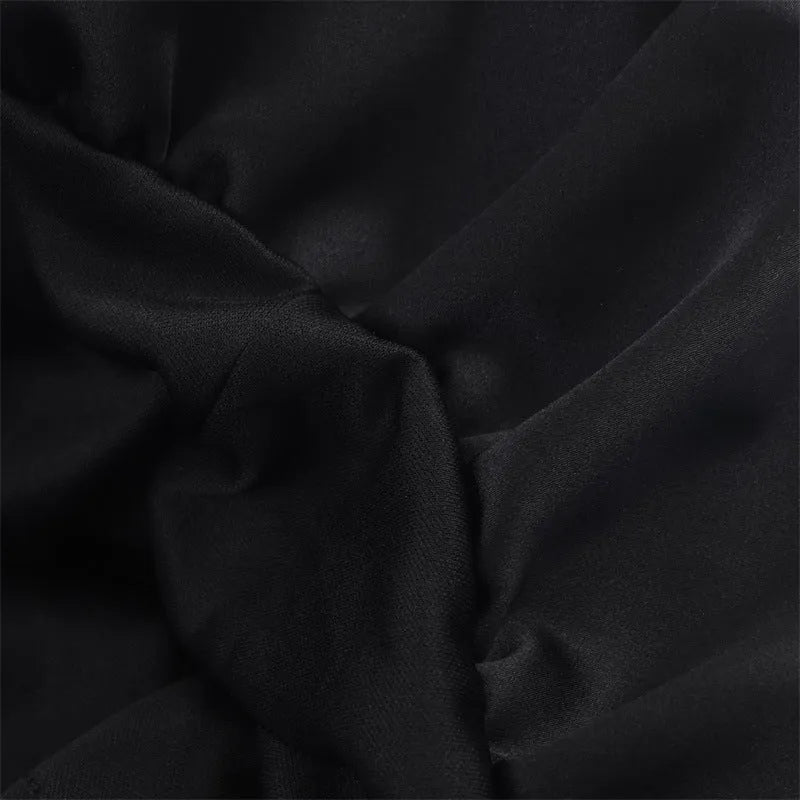 Women's black cotton short dress with lace stitching and asymmetric skirt on a plain background