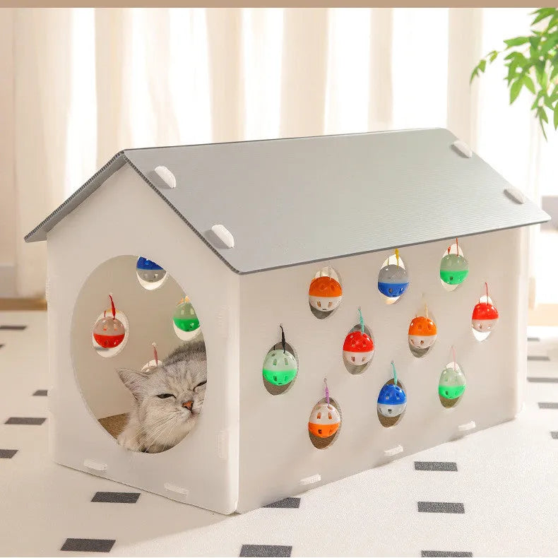 Plastic house-shaped cat scratch board with integrated bell ball toy for feline enrichment
