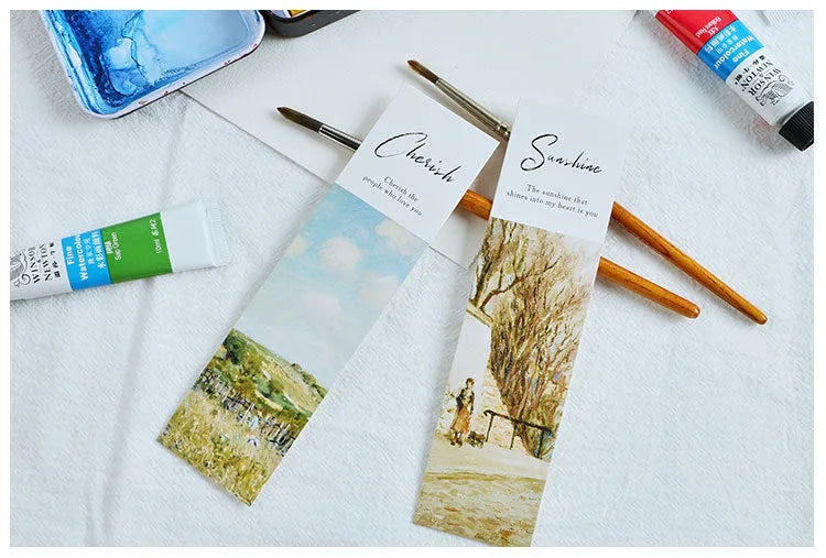 Pack of 30 white cardboard art bookmarks with designs including flowers and patterns, next to their plastic carton.