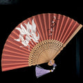Close-up of a traditional Chinese folding fan with intricate embroidery on a bamboo frame.