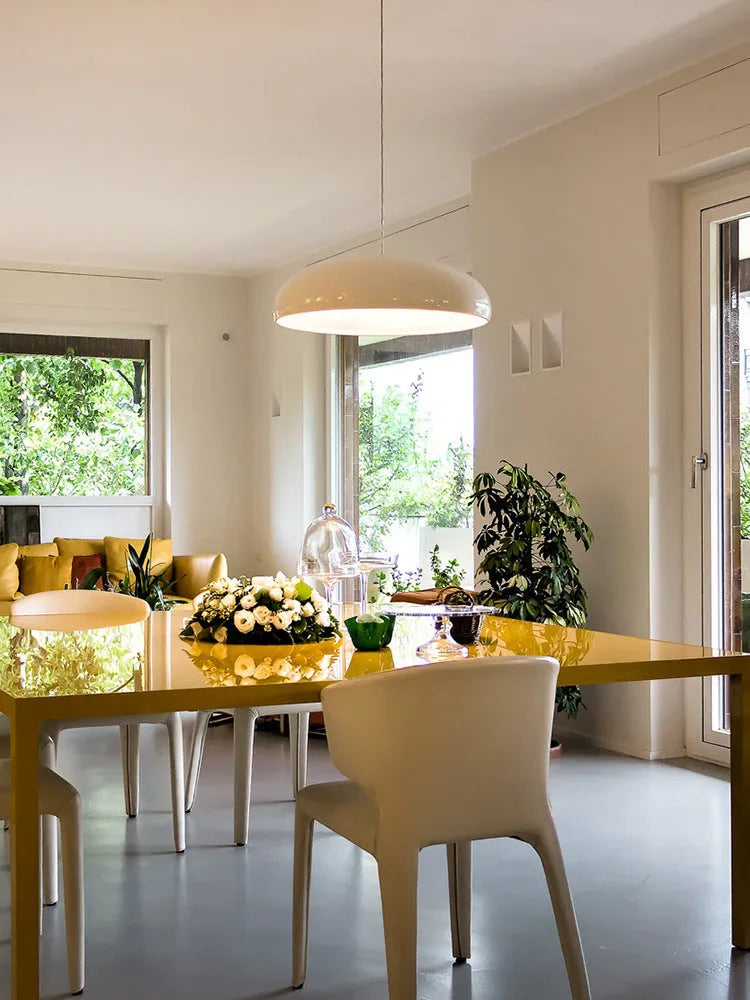 Danish-style iron pendant lamp with adjustable cord above a restaurant table.