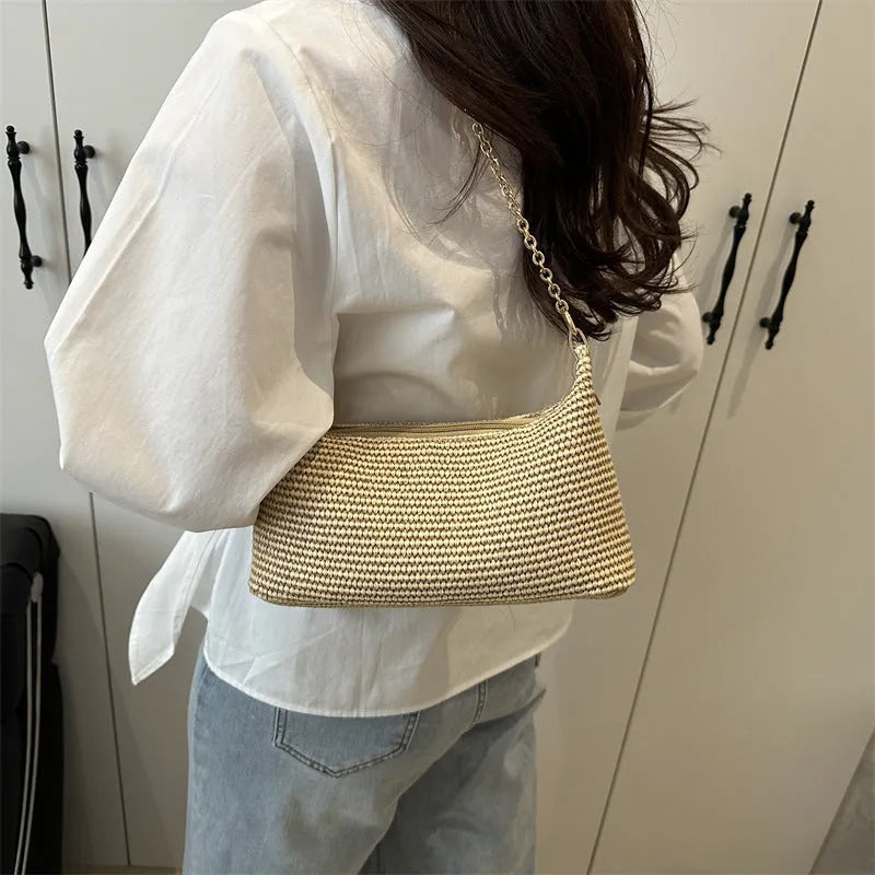 Khaki straw woven horizontal square tote bag with shoulder straps and outer sandwich pocket.