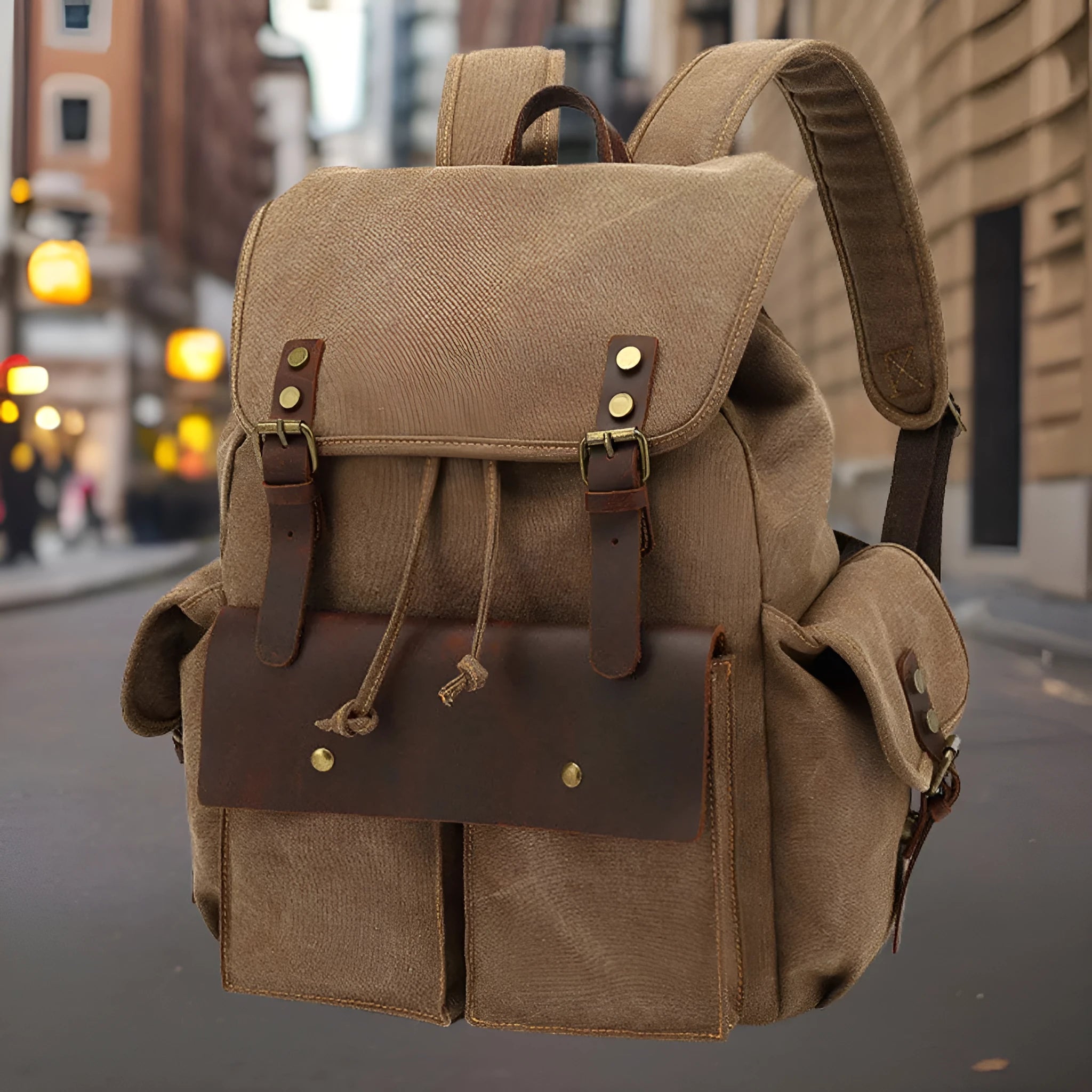 Retro canvas backpack in khaki colour with antique bronze hardware, showing front compartments and straps.