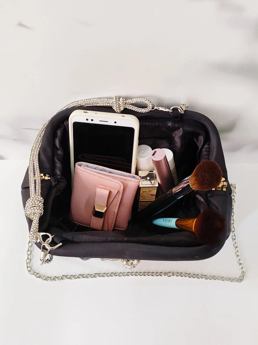 Soft black polyester women's shoulder messenger bag showing chain detail and fold styling.
