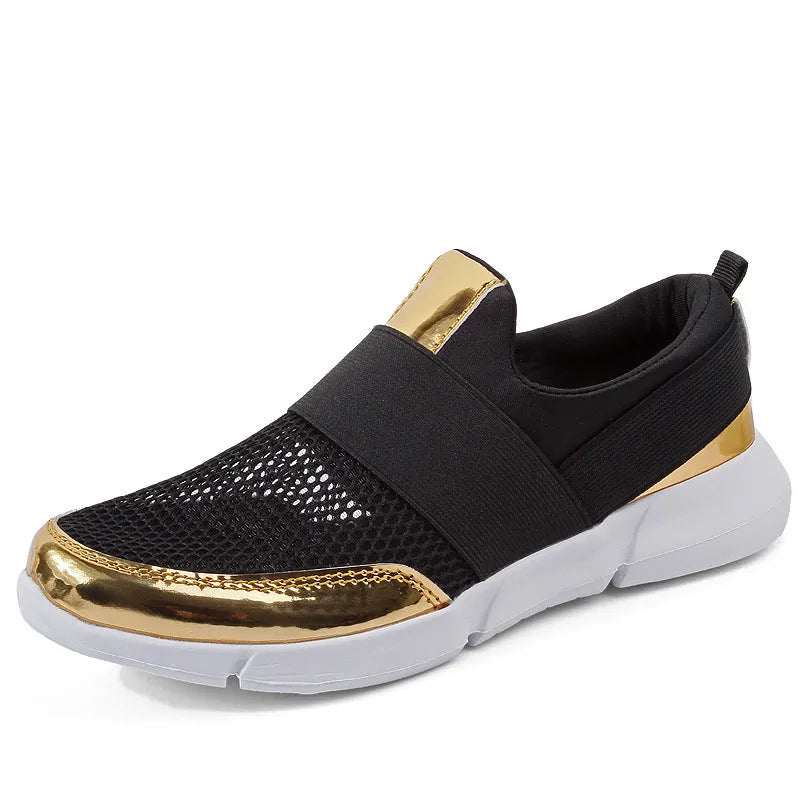 A pair of blue, low-cut women's casual sneakers with a mesh lining on a hard floor surface.