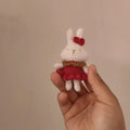 Hand-crocheted wool rabbit keychain pendant on a metal ring.