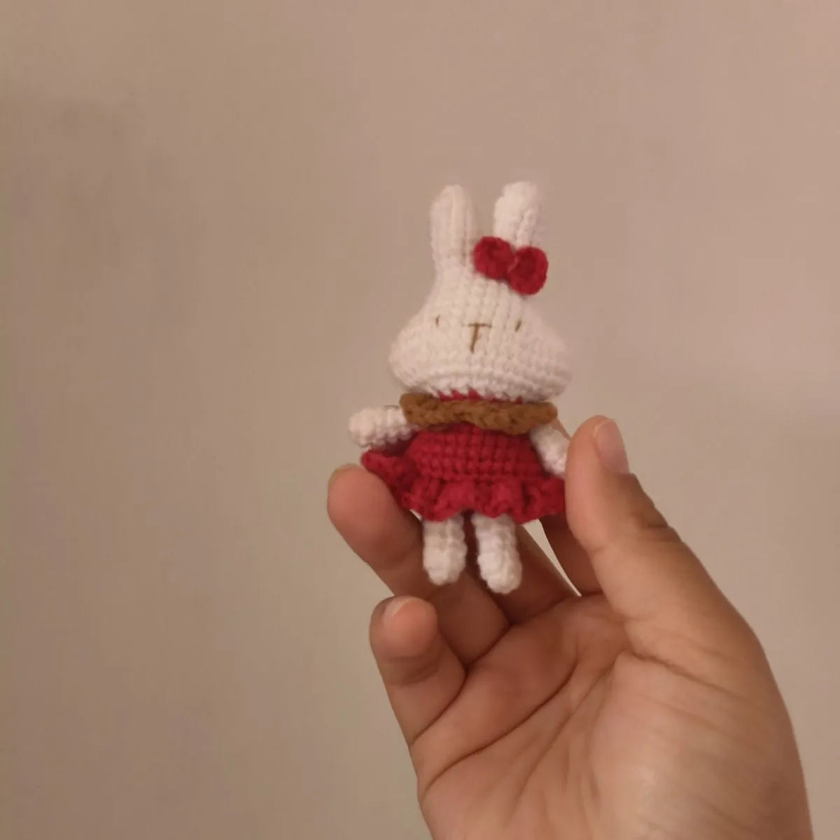 Hand-crocheted wool rabbit keychain pendant on a metal ring.