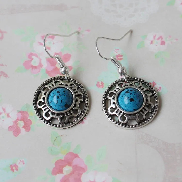 Handmade Miao silver and turquoise geometric flower disk earrings with ethnic patterns.