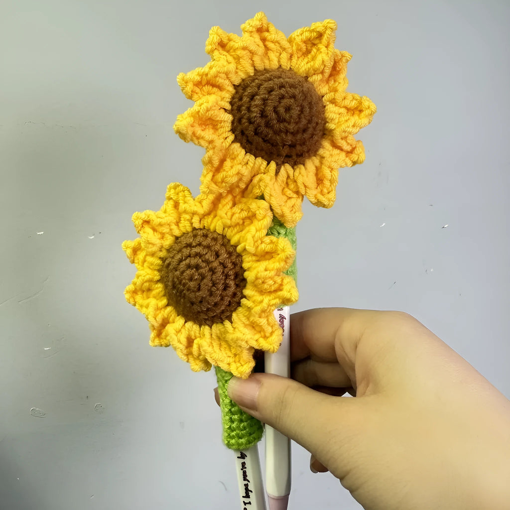 Hand-woven rattan sunflower pen cover holding a wooden pen on a desk.