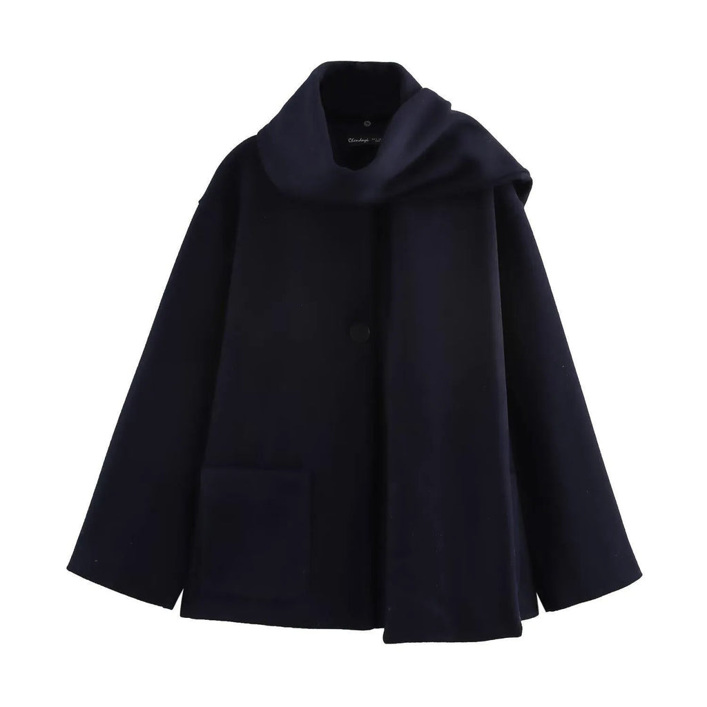 Women's long grey overcoat with a fluffy artificial fur collar, styled in a street fashion setting.
