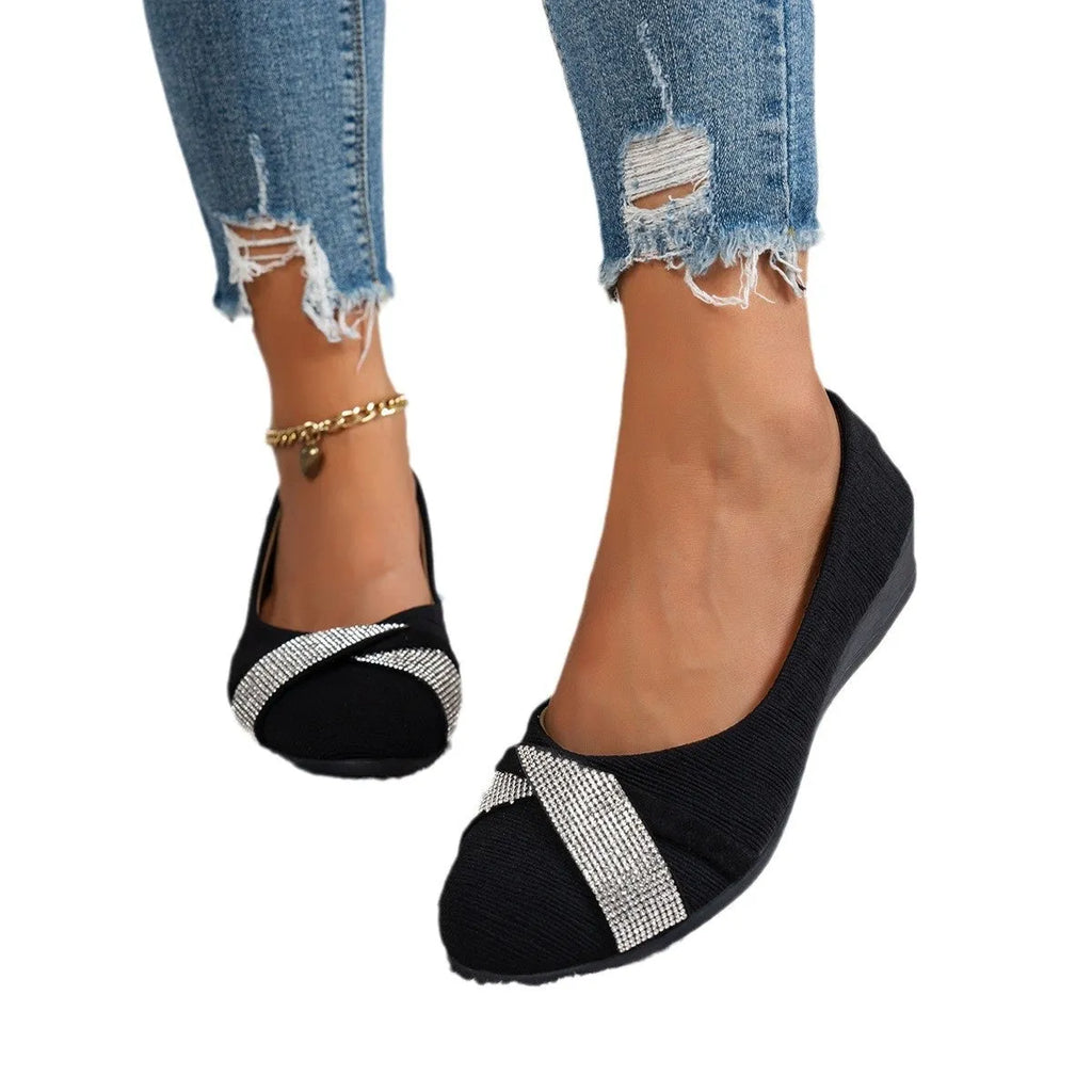 Women's black low-cut slip-on casual shoes with rhinestone detail and a short chunky heel.