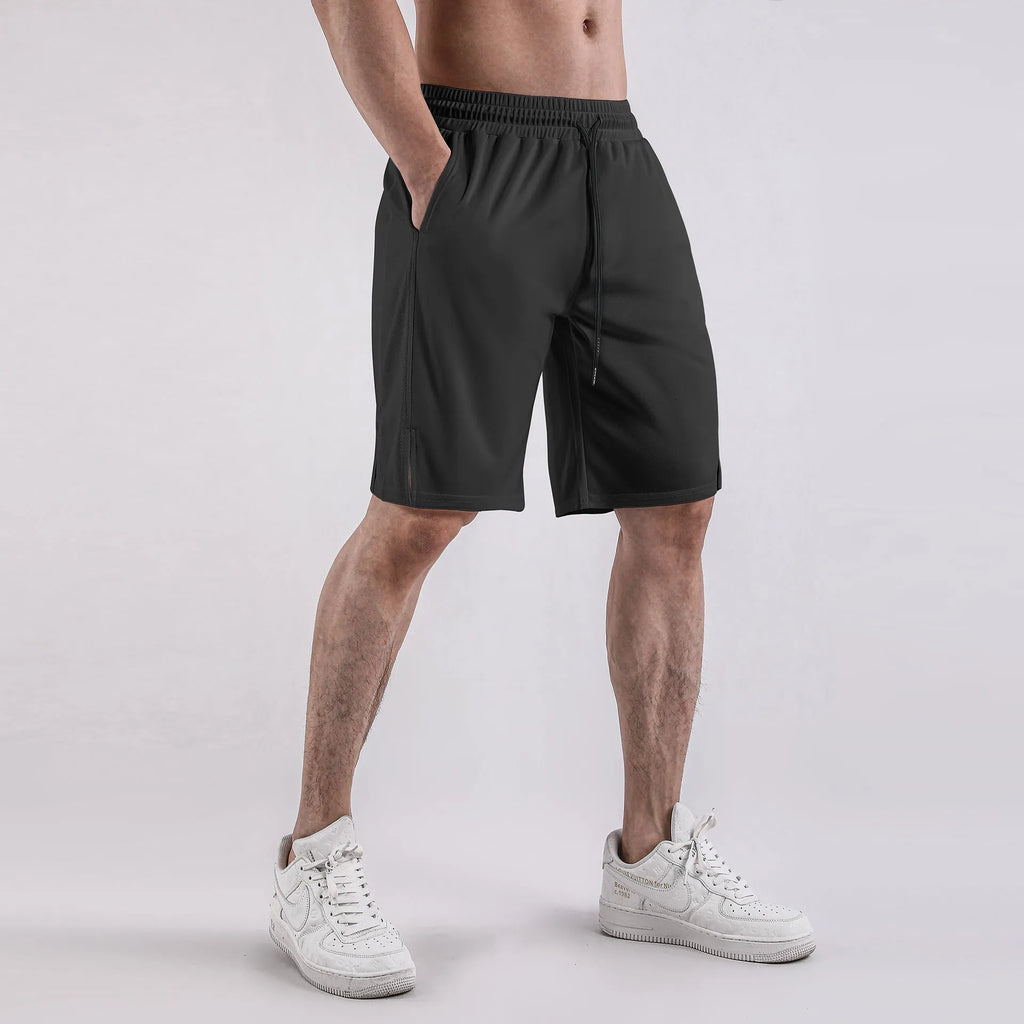 Man wearing black quick-drying mesh fitness shorts with an elastic mid-waist and loose fit.