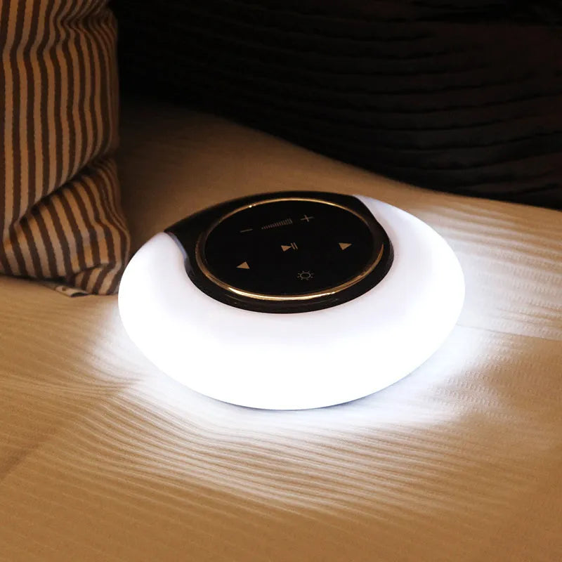Blue and white Bluetooth speaker desk lamp with folded head on a wooden table, showing touch panel.