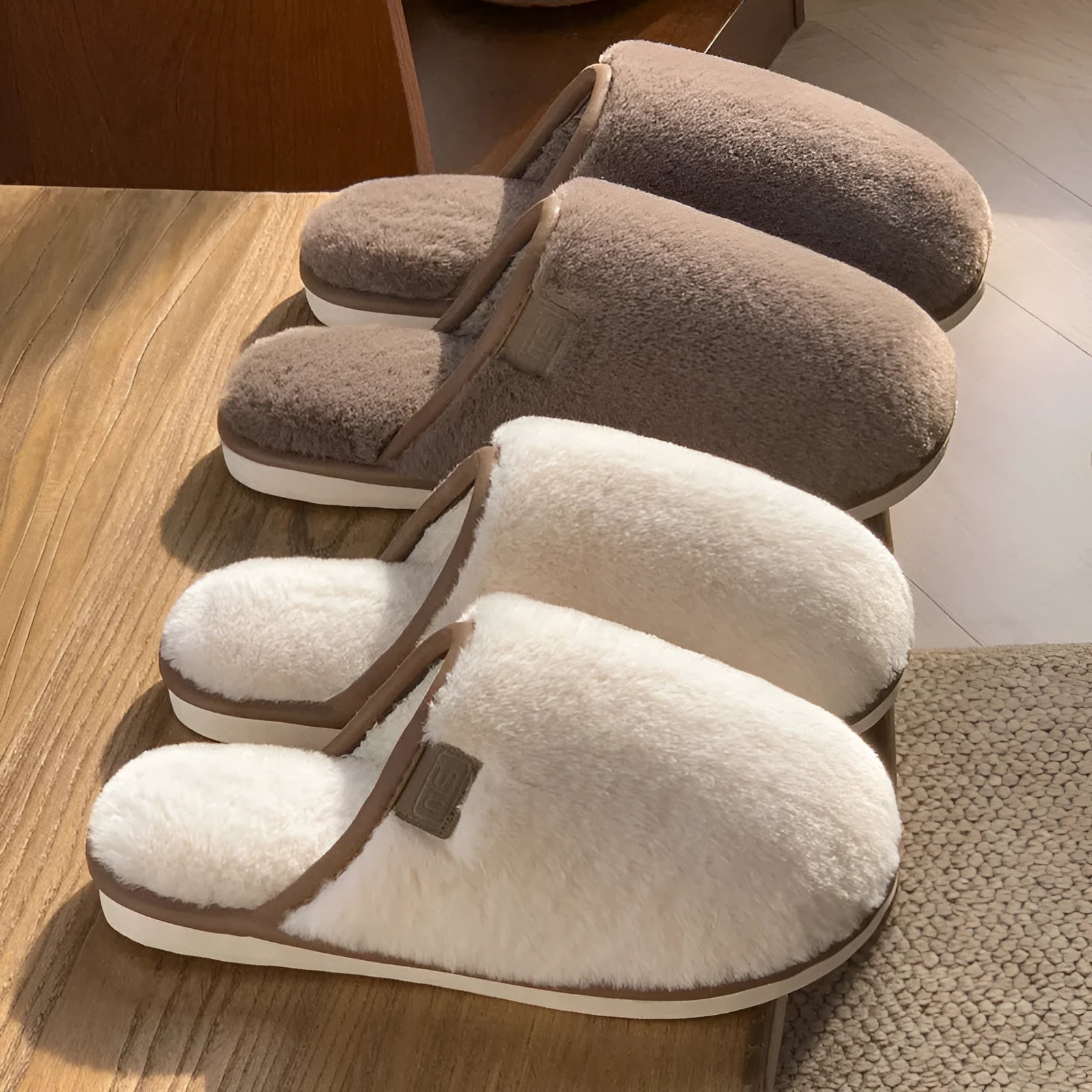 A pair of solid-colour plush winter slippers with a non-slip PVC sole on a wooden floor.