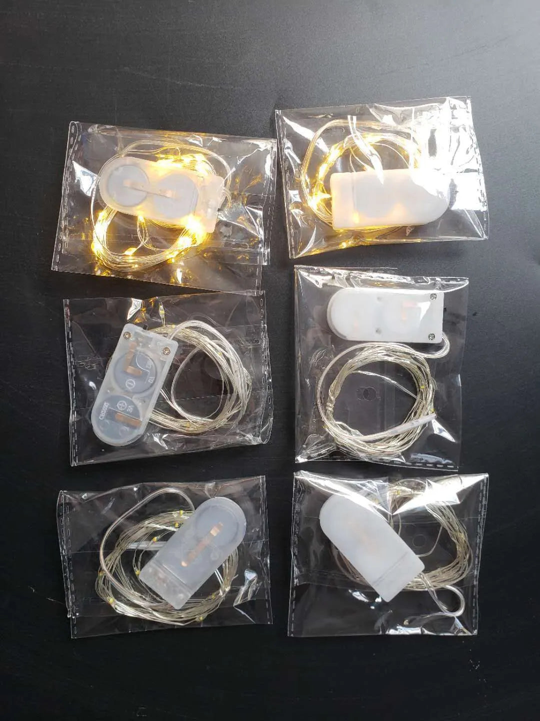 Bendable copper wire LED light string with plastic battery box, showing warm white and white light colour options.