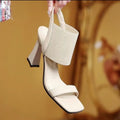 Women's high heel sandals with elastic straps in black, shown from the side.