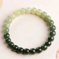 Natural Hetian Jade bracelet with gradient clear water colour on wrist, showing polished beads.