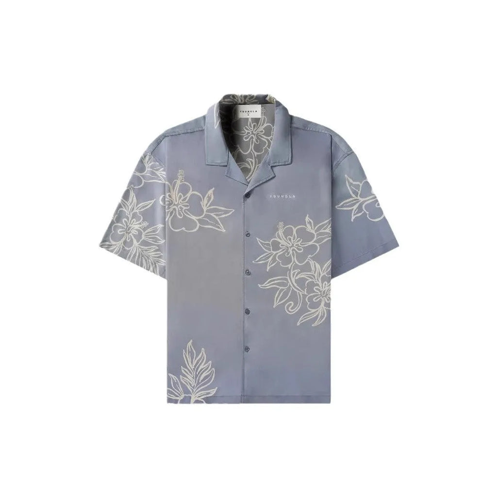 A loose-fitting short sleeve top with a floral print in a light colour, laid flat.