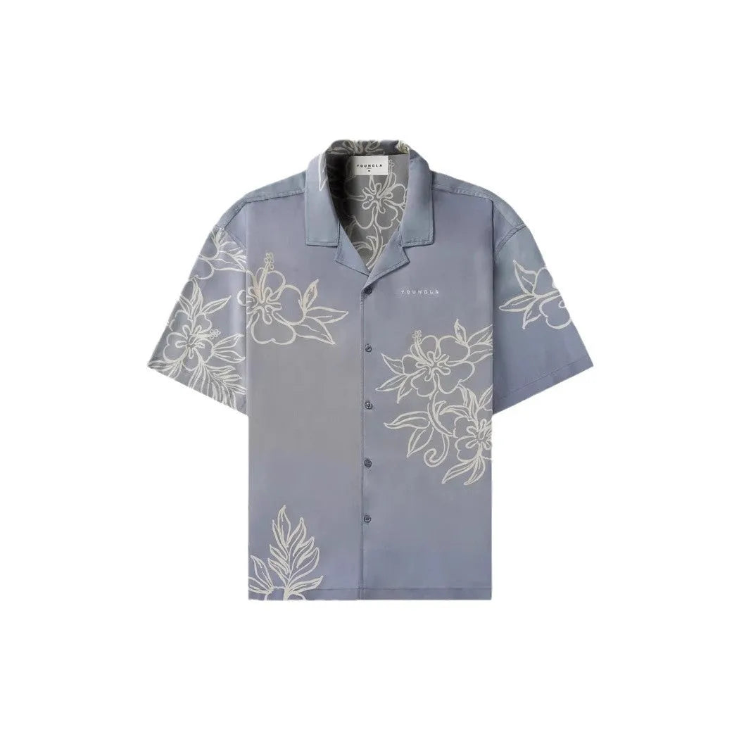 A loose-fitting short sleeve top with a floral print in a light colour, laid flat.