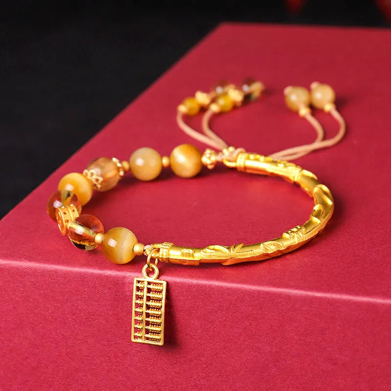 Handmade beaded bracelet featuring tigereye and citrine stones with yellow tower crystal and diamond-shaped copper parts