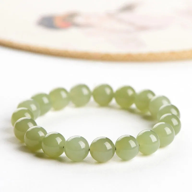 A polished Hetian jade ball bracelet showing beads in a clear ice-like colour on a wrist.