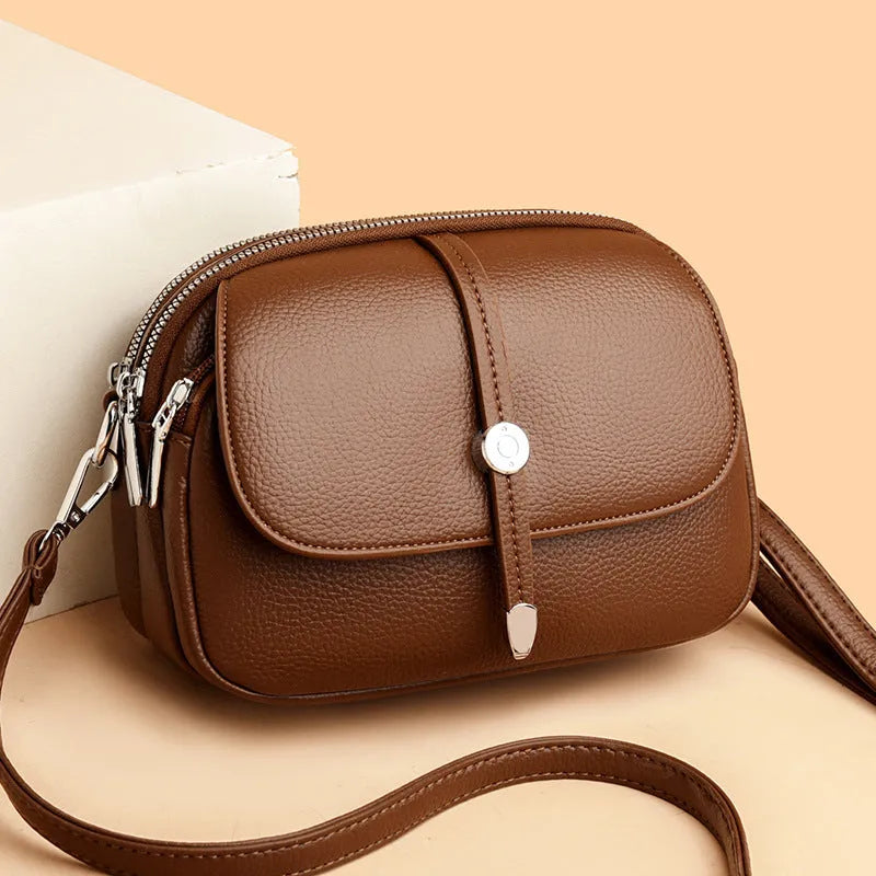 Women's soft PU leather crossbody shoulder bag in oval suitcase shape, shown in black colour with decorative sewing thread detailing.