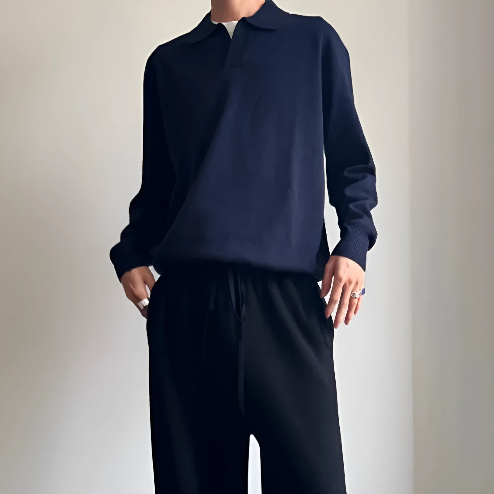 Man wearing a milky white pure wool polo sweater with a lapel collar, showcasing its loose fit.