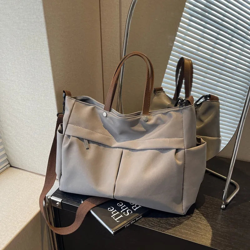Nylon crossbody bag with adjustable strap in black colour, showing tote design with 39cm length