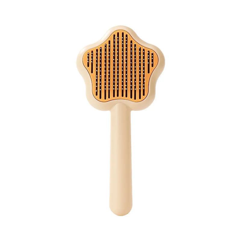 Green and yellow self-cleaning stainless steel cat comb with needle teeth on a wooden table.