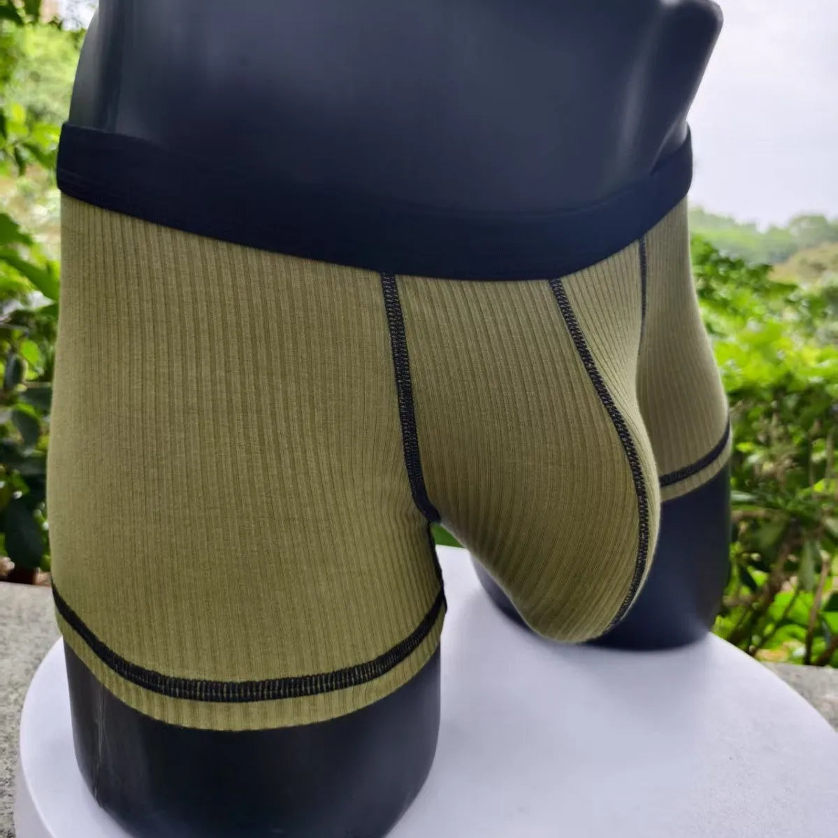Men's solid colour boxer shorts in thin fabric, shown in army green, highlighting breathable and body-shaping design.