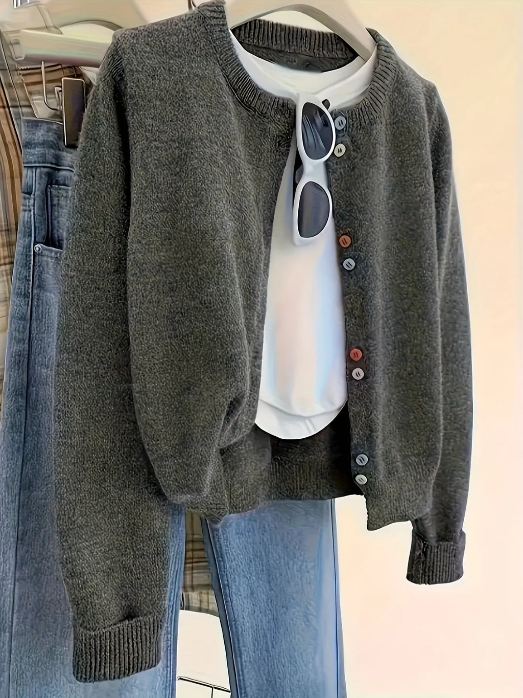 Dark grey women's button-front cardigan sweater with long sleeves on a hanger