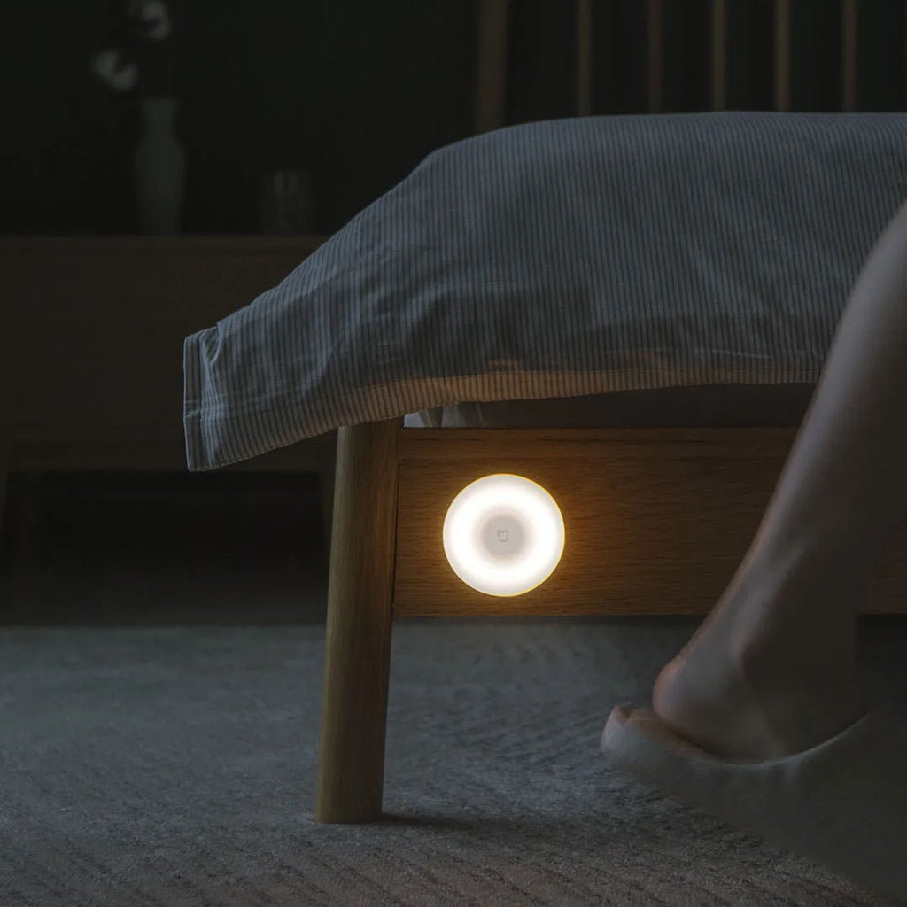 White Bluetooth induction bedside lamp with modern simple design on wooden nightstand